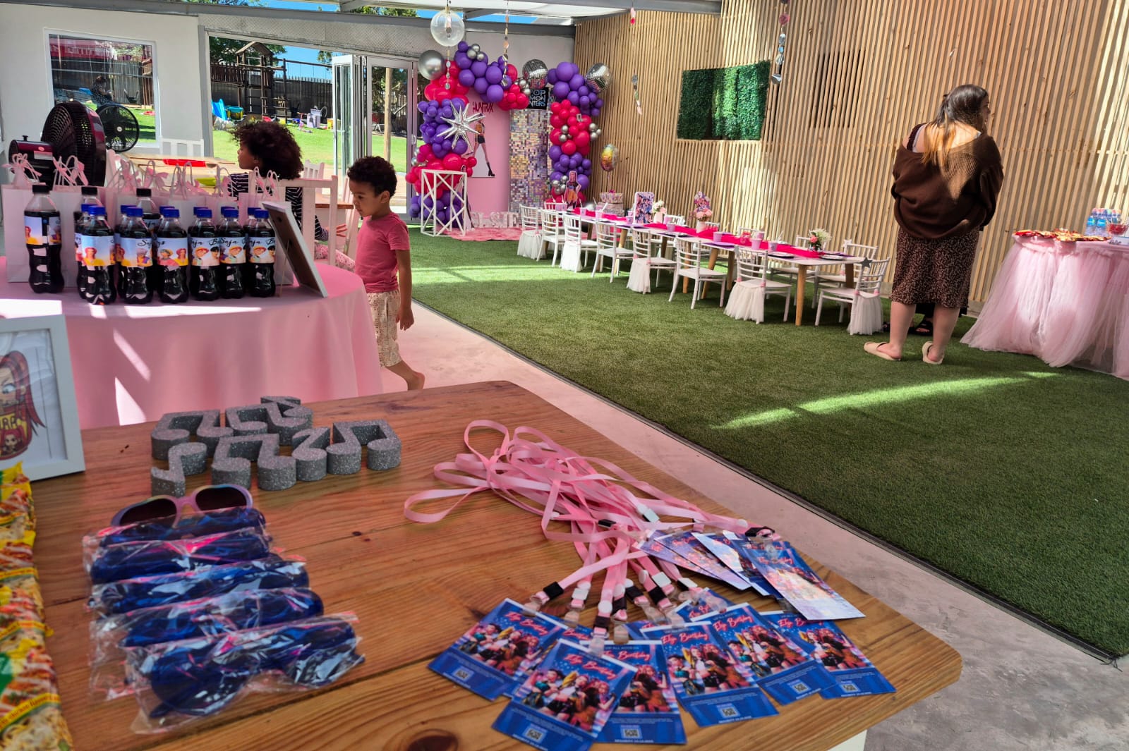 Pop star themed party set up across the hall with a balloon arch backdrop, kids’ table and VIP lanyards